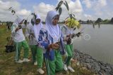 Pelajar menyiapkan bibit pohon durian (Durio zibethinus) saat penanaman di tepi Danau Sipin, Legok, Jambi, Jumat (4/8/2023). Penanaman puluhan batang pohon yang melibatkan sejumlah pelajar dan komunitas itu dalam rangka kampanye penyelamatan Daerah Aliran Sungai (DAS) Batanghari dalam rangkaian Kenduri Swarnabhumi 2023 di Kota Jambi. ANTARA FOTO/Wahdi Septiawan/foc.