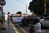 Petugas PT KAI (Persero) bersama Komunitas Masyarakat Pecinta Kereta Api dan taruna Politeknik Perkeretaapian Indonesia Madiun melakukan sosialisasi  keselamatan berlalu lintas di perlintasan sebidang di Kota Madiun, Jawa Timur, Minggu (6/8/2023). Kegiatan tersebut dimaksudkan untuk meningkatkan kesadaran masyarakat dalam menaati aturan lalu lintas, menyusul masih seringnya terjadi kecelakaan lalu lintas di perlintasan sebidang. ANTARA Jatim/Siswowidodo/ZK