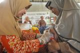 Tenaga medis mengukur panjang bayi saat pelaksanaan Pos Pelayanan Keluarga Berencana Kesehatan Terpadu (Posyandu) di Kota Bengkulu, Provinsi Bengkulu, Kamis (10/8/2023). Pemerintah menargetkan penurunan stunting secara nasional di tahun 2024 sebesar 14 persen dibandingkan pada tahun 2023 sebesar 21 persen. ANTARA FOTO/Muhammad Izfaldi/Spt.
