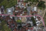 Foto udara bendera Merah Putih terbentang di Desa Sukamenak, Kabupaten Tasikmalaya, Jawa Barat, Sabtu (12/8/2023). Lorong bendera Merah Putih yang menghiasi jalan perkampungan sepanjang 250 meter itu dibuat warga secara swadaya dalam rangka memeriahkan HUT ke-78 Kemerdekaan RI. ANTARA FOTO/Adeng Bustomi/agr