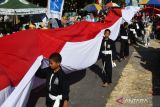 Sejumlah orang mengirab bendera Merah Putih sepanjang 78 meter di Tegalarum, Magetan, Jawa Timur, Minggu (13/8/2023). Kirab bendera Merah Putih oleh 78 orang terdiri pesilat, anggota Linmas, dan warga setempat tersebut dalam rangka memeriahkan HUT ke-78 Proklamasi Kemerdekaan RI. ANTARA Jatim/Siswowidodo/zk
