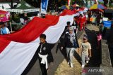 Sejumlah orang mengirab bendera Merah Putih sepanjang 78 meter di Tegalarum, Magetan, Jawa Timur, Minggu (13/8/2023). Kirab bendera Merah Putih oleh 78 orang terdiri pesilat, anggota Linmas, dan warga setempat tersebut dalam rangka memeriahkan HUT ke-78 Proklamasi Kemerdekaan RI. ANTARA Jatim/Siswowidodo/zk