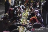 Warga makan nasi liwet bersama saat acara hajat lembur di Gunung Roay, Kota Tasikmalaya, Jawa Barat, Senin (14/8/2023) malam. Makan liwet bersama sepanjang 700 meter itu dalam rangka memeriahkan HUT ke-78 RI dan membangkitkan semangat gotong royong serta menjaga tali silahturahmi. ANTARA FOTO/Adeng Bustomi/agr