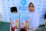 Dua orang anak menunjukkan produk susu ikan saat peluncuran di Kandanghaur, Indramayu, Jawa Barat, Selasa (15/8/2023). Teten Masduki mengatakan susu Ikan Produksi PT Berikan Protein Initative itu diharapkan bisa menjadi solusi permasalahan Stunting di Indonesia. ANTARA FOTO/Dedhez Anggara/agr