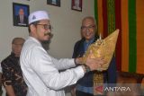 Direktur Utama Perum LKBN ANTARA, Akhmad Munir (kanan) bersiap mengenakan Kopiah Meukutop Aceh saat prosesi peusejuk  secara adat oleh tokoh ulama di Banda Aceh, Aceh, Senin (14/8/2023). Kunjungan Dirut LKBN ANTARA, Akhmad Munir ke Aceh itu, dalam rangka program tanggungjawab sosial lingkungan transplantasi terumbu karang dan pengibaran bendera dalam rangka HUT ke 78 RI di Pulau Sabang. ANTARA FOTO/Ampelsa.