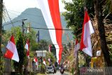 Warga melintas di bawah bendera Merah Putih yang terpasang di kawasan Banjar Pangi, Desa Pikat, Klungkung, Bali, Selasa (15/8/2023). Bendera dengan panjang sekitar 400 meter itu dipasang warga setempat untuk menyambut peringatan HUT ke-78 Kemerdekaan Republik Indonesia. ANTARA FOTO/Fikri Yusuf/wsj.