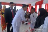 Pj Gubernur Aceh, Achmad Marzuki (tengah) didamping Plh Kepala Kanwil Kemenkuham Aceh, Lilik Sujandi (kedua kiri) menyerahkan surat remisi kepada warga binaan seusai upacara memperingati HUT ke 78  Kemerdekaan RI  di Lapas Kelas II A, Banda Aceh, Aceh, Kamis (17/8/2023). Pada peringatan HUT ke 78 Kemerdekaan RI, Kementerian Hukum dan Hak Azasi Manusia (Kemenkumham) memberikan remisi kepada  175.510  orang warga binaan yang terbagi dalam dua kategori, yakni remisi umum I  atau pengurangan sebagian masa tahanan sebanyak 172.904 narapidana dan remisi umum II atau langsung bebas sebanyak 2.606 narapidana. ANTARA FOTO/Ampelsa.