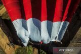 Foto udara Anggota Brimob Polda Jabar bersama anggota SAR Unpad mengibarkan bendera merah putih di Jembatan Cincin, Jatinangor, Kabupaten Sumedang, Jawa Barat, Kamis (17/8/2023). Pengibaran bendera selebar 10 x 20 meter itu dalam rangka peringatan HUT ke-78 RI di jembatan yang merupakan jembatan kereta nonaktif yang telah ada sejak zaman kolonial Belanda. ANTARA FOTO/Raisan Al Farisi/agr