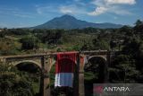 Foto udara Anggota Brimob Polda Jabar bersama anggota SAR Unpad mengibarkan bendera merah putih di Jembatan Cincin, Jatinangor, Kabupaten Sumedang, Jawa Barat, Kamis (17/8/2023). Pengibaran bendera selebar 10 x 20 meter itu dalam rangka peringatan HUT ke-78 RI di jembatan yang merupakan jembatan kereta nonaktif yang telah ada sejak zaman kolonial Belanda. ANTARA FOTO/Raisan Al Farisi/agr