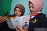 Dua siswa membaca brosur Lembaga Penjamin Simpanan di Bank Mini Syariah SMK Zainul Hasan, Balung, Jember, Jawa Timur, Jumat (18/8/2023). Lembaga Penjamin Simpanan (LPS) memberikan edukasi kepada lembaga pendidikan dan pelajar yang menjadi nasabah bank untuk menyimpan uang di lembaga keuangan yang dijamin oleh LPS. ANTARA Jatim/Seno/ZK