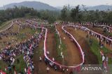 Foto udara warga membentangkan bendera Merah Putih di Sirkuit Serdadu, Kecamatan Langkaplancar, Kabupaten Pangandaran, Jawa Barat, Sabtu (19/8/2023). Kirab bendera Merah Putih sepanjang 4.000 meter dan 1.500 tiang yang bertema 