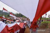 Warga membentangkan bendera Merah Putih di Sirkuit Serdadu, Kecamatan Langkaplancar, Kabupaten Pangandaran, Jawa Barat, Sabtu (19/8/2023). Kirab bendera Merah Putih sepanjang 4.000 meter dan 1.500 tiang yang bertema 