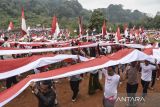 Warga membentangkan bendera Merah Putih di Sirkuit Serdadu, Kecamatan Langkaplancar, Kabupaten Pangandaran, Jawa Barat, Sabtu (19/8/2023). Kirab bendera Merah Putih sepanjang 4.000 meter dan 1.500 tiang yang bertema 