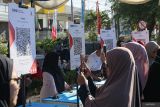 Pengunjung memindai kode Quick Response Code Indonesian Standard (QRIS) pada acara Pekan QRIS Nasional 2023 saat Car Free Day (CFD) di Banda Aceh, Aceh, Minggu (20/8/2023). Pekan QRIS Nasional 2023 tersebut merupakan upaya BI mengkampanyekan penggunaan QRIS sebagai alat pembayaran non tunai di tengah masyarakat dengan target 45 juta pengguna baru dan 1 miliar transaksi QRIS pada tahun 2023 secara nasional. ANTARA/Khalis Surry
