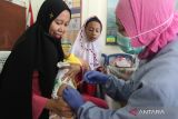 Petugas medis menyuntikkan vaksin polio kepada balita dalam pelaksanaan Program Imunisasi Ganda atau pemberian dua jenis vaksin yang berbeda pada satu waktu di kantor kelurahan Bunulrejo, Malang, Jawa Timur, Jumat (18/8/2023). Pemerintah setempat menggalakkan pelaksanaan program imunisasi ganda sebanyak dua kali dalam sebulan di setiap kelurahan di Kota Malang guna mengejar keterlambatan imunisasi pada anak dengan jenis vaksin antara lain DPT, Pneumococcal Conjugate Vaccine (PCV), polio serta rotavirus. ANTARA Jatim/Ari Bowo Sucipto/zk 