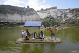 Gubernur Jawa Timur Khofifah Indar Parawansa (kiri) menaiki perahu rakit bambu saat berkunjung ke lokasi wisata Bukit Jaddih di Bangkalan, Jawa Timur, Selasa (22/8/2023). Kunjungan Gubernur Khofifah tersebut dalam rangka melihat secara langsung potensi destinasi wisata berbasis desa di daerah tersebut sebagai bentuk komitmen untuk pengembangan wisata di Jawa Timur. Antara Jatim/Moch Asim/zk.