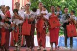 Sejumlah ibu menggendong anaknya saat menerima paket bantuan untuk anak pada acara Gemar Makan Ikan (GEMARI) di Kantor Lurah Serangan, Denpasar, Bali, Sabtu (26/8/2023). Kegiatan yang digelar Kementerian PPPA itu memberikan sosialisasi dan edukasi terkait peran perempuan Gemar Makan Ikan serta mengajak masyarakat agar memperbanyak mengonsumsi ikan guna meningkatkan kecerdasan otak dan menjaga kesehatan tubuh sekaligus sebagai upaya mencegah stunting. ANTARA FOTO/Nyoman Hendra Wibowo/wsj.