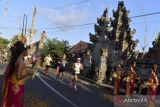 Peserta disambut penampilan kesenian Bali saat mengikuti Maybank Bali Marathon 2023 di Gianyar, Bali, Minggu (27/8/2023). Ajang lomba Elite Label Road Race satu-satunya di Indonesia tersebut diikuti 13.600 orang pelari dari 50 negara. ANTARA FOTO/Fikri Yusuf/wsj.