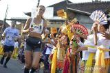 Peserta disambut penampilan kesenian Bali saat mengikuti Maybank Bali Marathon 2023 di Gianyar, Bali, Minggu (27/8/2023). Ajang lomba Elite Label Road Race satu-satunya di Indonesia tersebut diikuti 13.600 orang pelari dari 50 negara. ANTARA FOTO/Fikri Yusuf/wsj.