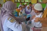 Petugas Puskesmas menyuntikkan cairan vaksin kepada murid dan dilanjutkan skrining kesehatan saat berlangsung Bulan Imunisasi Anak Sekolah (BIAS) di SDN 20, Banda Aceh, Aceh, Senin (28/8/2023). Bulan Imunisasi Anak Sekolah (BIAS) untuk meningkatkan perlindungan terhadap penyakit campak, rubella, difteri, tetanus, dan kanker leher rahim juga disertai dengan skrining kesehatan pemeriksaan mata, gigi, mulut, telinga dan berat badan pada murid itu untuk mendeteksi sedini mungkin pelajar  yang memiliki masalah kesehatan. ANTARA FOTO/Ampelsa.