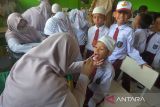 Petugas Puskesmas melakukan skrining pemeriksaan kesehatan mulut dan gigi pada murid seusai memberikan vaksin  saat berlangsung Bulan Imunisasi Anak Sekolah (BIAS) di SDN 20, Banda Aceh, Aceh, Senin (28/8/2023). Bulan Imunisasi Anak Sekolah (BIAS) untuk meningkatkan perlindungan terhadap penyakit campak, rubella, difteri, tetanus, dan kanker leher rahim juga disertai dengan skrining kesehatan pemeriksaan mata, gigi, mulut, telinga dan berat badan pada murid itu untuk mendeteksi sedini mungkin pelajar  yang memiliki masalah kesehatan. ANTARA FOTO/Ampelsa.