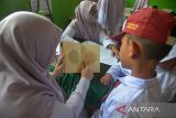 Petugas Puskesmas melakukan skrining tes buta warna kepada murid  seusai memberikan vaksin saat berlangsung Bulan Imunisasi Anak Sekolah (BIAS) di SDN 20, Banda Aceh, Aceh, Senin (28/8/2023). Bulan Imunisasi Anak Sekolah (BIAS) untuk meningkatkan perlindungan terhadap penyakit campak, rubella, difteri, tetanus, dan kanker leher rahim juga disertai dengan skrining kesehatan pemeriksaan mata, gigi, mulut, telinga dan berat badan pada murid itu untuk mendeteksi sedini mungkin pelajar  yang memiliki masalah kesehatan. ANTARA FOTO/Ampelsa.