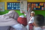 Petugas Puskesmas melakukan skrining tes mata kepada murid seusai memberikan vaksin saat berlangsung Bulan Imunisasi Anak Sekolah (BIAS) di SDN 20, Banda Aceh, Aceh, Senin (28/8/2023). Bulan Imunisasi Anak Sekolah (BIAS) untuk meningkatkan perlindungan terhadap penyakit campak, rubella, difteri, tetanus, dan kanker leher rahim juga disertai dengan skrining kesehatan pemeriksaan mata, gigi, mulut, telinga dan berat badan pada murid itu untuk mendeteksi sedini mungkin pelajar  yang memiliki masalah kesehatan. ANTARA FOTO/Ampelsa.