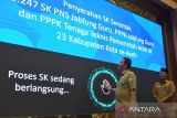 PJ Gubernur Aceh, Ahmad Marzuki (kiri) melakukan sidik jari untuk mengakses secara online Surat Keputusan (SK) Pegawai Pemerintahan dengan Perjanjian Kerja (PPPK) di seluruh kabupaten/kota saat pelantikan dan pengambilan sumpah di Banda Aceh, Aceh, Selasa (29/8/2023). Pemerintah provinsi Aceh menyerahkan Surat Keputusan (SK) Pengangkatan kepada sebanyak 3.247  PNS  jabatan fungsi guru, dan PPPK  jabatan fungsi guru serta  PPPK tenaga tehnis pemerintah Aceh.  ANTARA FOTO/Ampelsa.