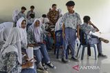 Siswa menunggu antrean pererekaman data identitas di SMA Negeri 1 Baregbeg, Kabupaten Ciamis, Jawa Barat, Kamis (31/8/2023). Disdukcapil Ciamis melakukan perekaman E-KTP bagi siswa dengan sistem jemput bola di sekolah untuk memfasilitasi hak pilih pada Pemilu 2024, dengan data pemilih pemula usia 17 tahun di Ciamis yang belum memiliki KTP sebanyak 12.133 orang. ANTARA FOTO/Adeng Bustomi/agr