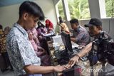Petugas Dinas Kependudukan dan Pencatatan Sipil (Disdukcapil) merekam data identitas siswa di SMA Negeri 1 Baregbeg, Kabupaten Ciamis, Jawa Barat, Kamis (31/8/2023). Disdukcapil Ciamis melakukan perekaman E-KTP bagi siswa dengan sistem jemput bola di sekolah untuk memfasilitasi hak pilih pada Pemilu 2024, dengan data pemilih pemula usia 17 tahun di Ciamis yang belum memiliki KTP sebanyak 12.133 orang. ANTARA FOTO/Adeng Bustomi/agr
