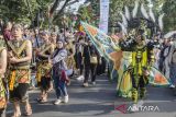 Gubernur Jawa Barat Ridwan Kamil (kanan) menyapa warga dengan menggunakan kostum saat mengikuti karnaval budaya West Java Festival di Bandung, Jawa Barat, Minggu (3/9/2023). Karnaval dengan tema 