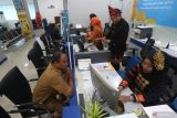Sejumlah petugas memakai pakaian adat saat melayani peserta Taspen di kantor PT. Taspen Banda Aceh, Aceh, Senin (4/9/2023). Pemakaian baju adat dari berbagai daerah nusantara dalam rangka memperingati Hari Pelanggan Nasional 2023. Antara Aceh/Irwansyah Putra.