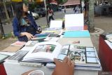 Dua mahasiswa membaca buku di Perpustakaan Fotografi Keliling di Taman Meja Catur Fakultas Ilmu Budaya Universitas Negeri Jember, Jawa Timur, Rabu (6/9/2023). Perpustakaan Fotografi Keliling ini bertujuan membumikan buku foto terbitan Indonesia dan luar negeri kepada masyarakat secara gratis, sebab buku foto masih terkesan eksklusif, dengan cara berkeliling Indonesia. Antara Jatim/Seno/zk.