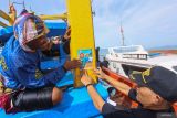 Petugas Pangkalan Sumber Daya Kelautan dan Perikanan (PSDKP) Lampulo Yusni (kanan) dan nelayan saat memasang stiker larangan membuang sampah ke laut di kapal perikanan tangkap milik nelayan di perairan laut Banda Aceh, Aceh, Kamis (7/9/2023). Kegiatan penempelan stiker larangan buang sampah ke laut dalam rangkaian program Bulan Cinta Laut 2023 Kementerian Kelautan dan Perikanan (KKP) sebagai gerakan untuk edukasi sekaligus kampanye menjaga kebersihan dan kesehatan laut agar terbebas dari pencemaran sampah plastik. ANTARA/Khalis Surry