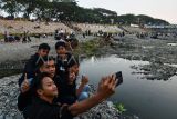 Sejumlah pengunjung berswafoto saat menikmati suasana di kawasan Sungai Madiun, Kota Madiun, Jawa Timur, Kamis (7/9/2023). Sejak sekitar dua bulan terakhir, musim kemarau mengakibatkan sebagian kawasan Sungai Madiun mengering dan menjadi objek wisata alternatif bagi warga dari Madiun serta daerah sekitar. ANTARA FOTO/Siswowidodo/rwa.