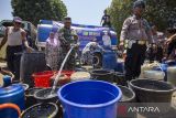 Personel Satlantas Polres Indramayu menyalurkan bantuan air bersih di Desa Dadap, Juntinyuat, Indramayu, Jawa Barat, Rabu (13/9/2023). Bantuan air bersih tersebut diberikan kepada daerah yang mengalami krisis air bersih terparah di Kabupaten Indramayu sekaligus memperingati HUT ke 68 Lalu Lintas. ANTARA FOTO/Dedhez Anggara/agr