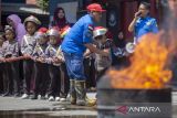 Siswa Taman Kanak-kanak (TK) Bhayangkari didampingi petugas Damkar melakukan simulasi pemadaman api di Indramayu, Jawa Barat, Kamis (14/9/2023). Kegiatan belajar mengajar di luar kelas itu bertujuan agar siswa dapat mengenal profesi pemadam kebakaran serta memberikan edukasi tentang cara penyelamatan dan memadamkan api secara mandiri. ANTARA FOTO/Dedhez Anggara/agr
