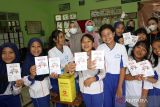 Anak-anak menunjukan kartu imunisasi usai mendapatkan vaksin Human Papillomavirus (HPV) di SDN Model Banyuwangi, Jawa Timur, Rabu (13/9/2023). Kementerian Kesehatan RI melalui Direktorat Jenderal Pencegahan dan Pengendalian Penyakit melakukan Pencanangan Imunisasi HPV secara nasional dalam rangka mempercepat penurunan angka kesakitan dan kematian akibat kanker leher rahim atau kanker serviks yang merupakan kanker penyebab kematian tertinggi kedua di Indonesia. ANTARA Jatim/Budi Candra Setya/zk 