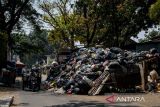 Kendaraan melintas di samping TPS Gudang Selatan, Bandung, Jawa Barat, Rabu (20/9/2023). Pemerintah Provinsi Jawa Barat mencatat, sebanyak 25 ribu ton sampah di Bandung Raya yang meliputi Kota Bandung, Cimahi, Kabupaten Bandung, dan Kabupaten Bandung Barat masih menumpuk di TPS dan sejumlah titik lainnya akibat area utama TPA Sarimukti masih terbakar. ANTARA FOTO/Raisan Al Farisi/agr