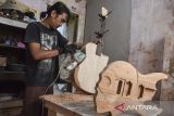 Perajin Ilham Firdaus menyelesaikan pembuatan gitar di industri rumahan I AM Guitar, Desa Cijulang, Kabupaten Ciamis, Jawa Barat, Rabu (27/9/2023). I AM Guitar memproduksi gitar custom akustik dan elektrik sesuai pesanan yang dikerjakan menggunakan alat sederhana serta telah menembus pasar ekspor ke Malaysia dengan harga Rp1,5 juta hingga Rp8 juta per unit. ANTARA FOTO/Adeng Bustomi/agr