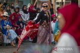 Peserta memperagakan busana dari kain batik dan kain bordir khas Indramayu pada Sukawera Fashion Show Street di Indramayu, Jawa Barat, Senin (2//10/2023). Peragaan busana yang digelar Ikatan Wanita Pengusaha Indonesia (Iwapi) Indramayu itu untuk mempromosikan kain batik dan kain bordir khas Indramayu sekaligus memperingati Hari Batik Nasional. ANTARA FOTO/Dedhez Anggara/agr
