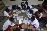  Sejumlah siswa SDN Gelang 7 belajar di teras rumah warga sekitar di Desa Gelang, Sumberbaru, Jember, Jawa Timur, Selasa (3/10/2023). Sebanyak 174 siswa terpaksa belajar di teras rumah warga selama dua bulan terakhir karena sekolahnya ambruk setahun yang lalu, dan kini masih dalam perbaikan. ANTARA Jatim/Seno/zk