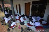 Sejumlah siswa SDN Gelang 7 belajar di teras rumah warga sekitar di Desa Gelang, Sumberbaru, Jember, Jawa Timur, Selasa (3/10/2023). Sebanyak 174 siswa terpaksa belajar di teras rumah warga selama dua bulan terakhir karena sekolahnya ambruk setahun yang lalu, dan kini masih dalam perbaikan. ANTARA Jatim/Seno/zk