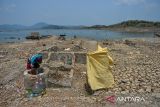 Warga mengambil air di pesisir Waduk Jatigede yang mengering di Darmaraja, Kabupaten Sumedang, Jawa Barat, Selasa (3/10/2023). Warga mengatakan sudah hampir tiga bulan, debit air Waduk Jatigede mengalami penyusutan sehingga permukiman warga di Desa Cipaku Kecamatan Darmaraja kembali muncul ke permukaan. ANTARA FOTO/Raisan Al Farisi/agr