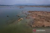 Foto udara permukiman warga yang muncul ke permukaan di pesisir Waduk Jatigede yang mengering di Darmaraja, Kabupaten Sumedang, Jawa Barat, Selasa (3/10/2023). Warga mengatakan sudah hampir tiga bulan, debit air Waduk Jatigede mengalami penyusutan sehingga permukiman warga di Desa Cipaku Kecamatan Darmaraja kembali muncul ke permukaan. ANTARA FOTO/Raisan Al Farisi/agr