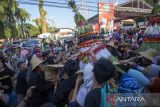 Warga berebut gunungan hasil bumi saat kirab budaya di Indramayu, Jawa Barat, Rabu (4/10/2023). Kirab budaya yang menampilkan berbagai kesenian tradisional dan hasil bumi itu digelar dalam rangka peringatan hari jadi ke-496 Kabupaten Indramayu. ANTARA FOTO/Dedhez Anggara/agr