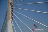 Pekerja memanjat kabel pancang dengan menggunakan alat pengaman diri saat mengecat Jembatan Layang Prof Mochtar Kusumaatmadja di Bandung, Jawa Barat, Jumat (6/10/2023). Pengecatan jalan layang yang menjadi ikon Kota Bandung tersebut merupakan bagian dari upaya perawatan untuk memperindah kota serta meningkatkan ketahanan konstruksinya. ANTARA FOTO/Raisan Al Farisi/agr