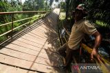 Warga bergantungan di besi saat melewati jembatan gantung yang terputus di Desa Alue Keujruen, Kecamatan Tanah Luas, Aceh Utara, Aceh. Selasa (10/10/2023). Putus dan ambruknya jembatan gantung penghubung enam kecamatan tersebut dikarenakan kondisi rekonstruksi tua sehingga tidak mampu menahan beban berat kendaraan roda empat yang kerap melewati jembatan tersebut. ANTARA/Rahmad