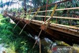Warga bergantungan di besi saat melewati jembatan gantung yang terputus di Desa Alue Keujruen, Kecamatan Tanah Luas, Aceh Utara, Aceh. Selasa (10/10/2023). Putus dan ambruknya jembatan gantung penghubung enam kecamatan tersebut dikarenakan kondisi rekonstruksi tua sehingga tidak mampu menahan beban berat kendaraan roda empat yang kerap melewati jembatan tersebut. ANTARA/Rahmad