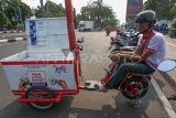 Barista Kojan Coffee membuat kopi di atas sepeda listrik di Jalan Raya Tegar Beriman, Cibinong, Kabupaten Bogor, Jawa Barat, Senin (9/10/2023). Kedai kopi keliling yang bisa dipanggil melalui aplikasi dalam jaringan (online) itu dimanfaatkan warga untuk menikmati kopi ala kafe dengan harga terjangkau mulai dari Rp8.000 hingga Rp15.000. ANTARA FOTO/Yulius Satria Wijaya/nz.